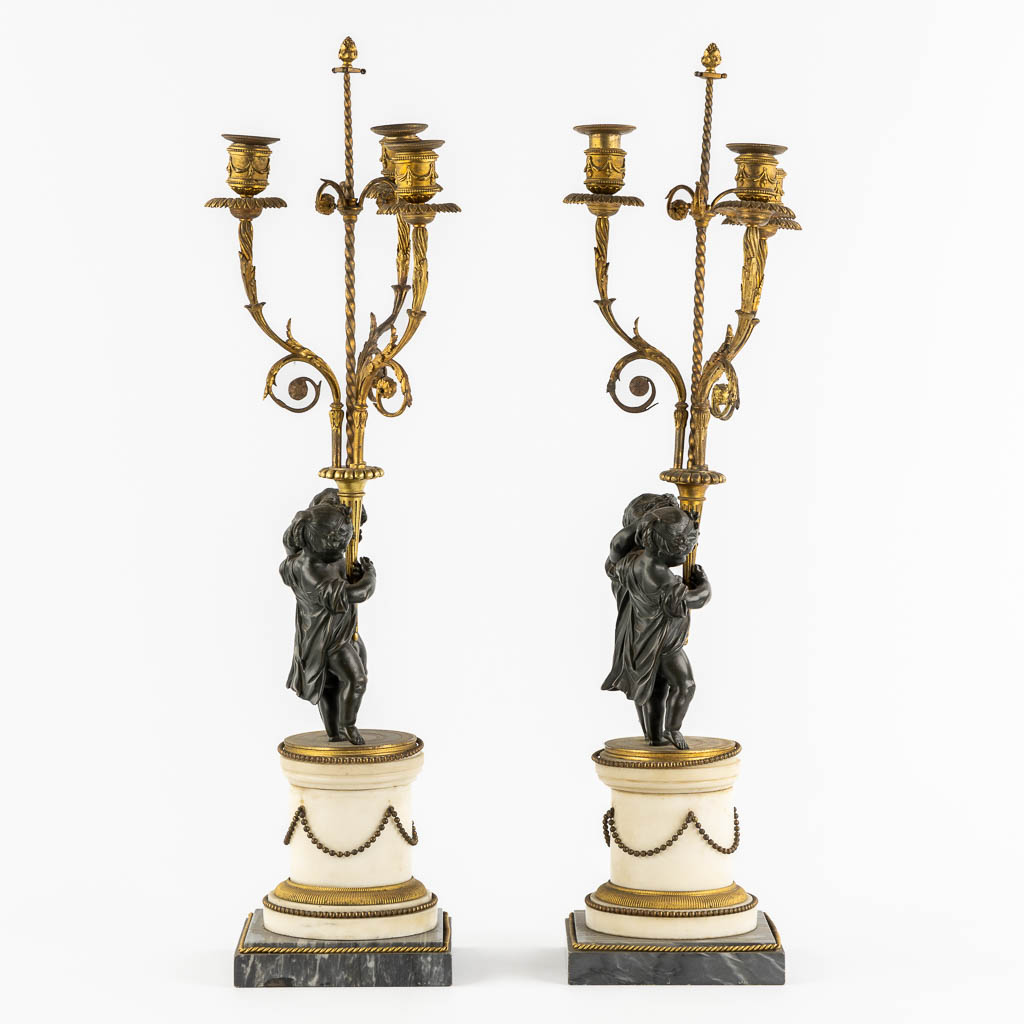 A pair of Marble, gilt and patinated bronze candelabra with putti, Louis XVI style, 19th C. (L:16,5 x W:16,5 x H:71,5 cm)