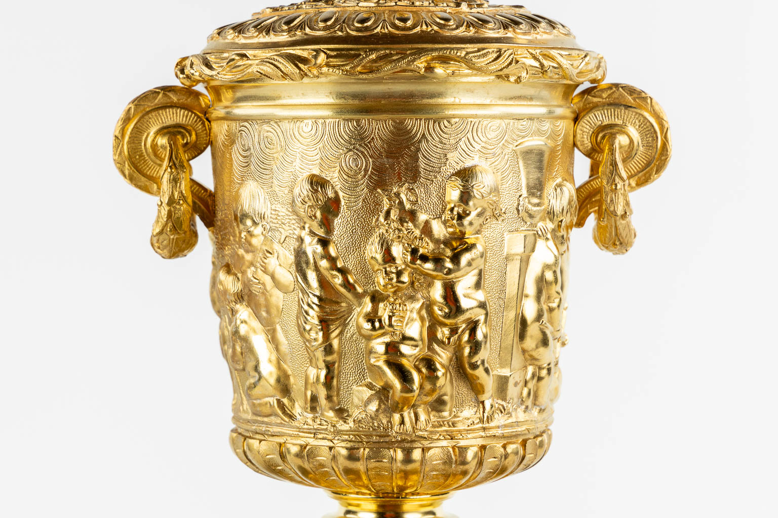 A gilt bronze mantle clock, richly decorated with putti, ram