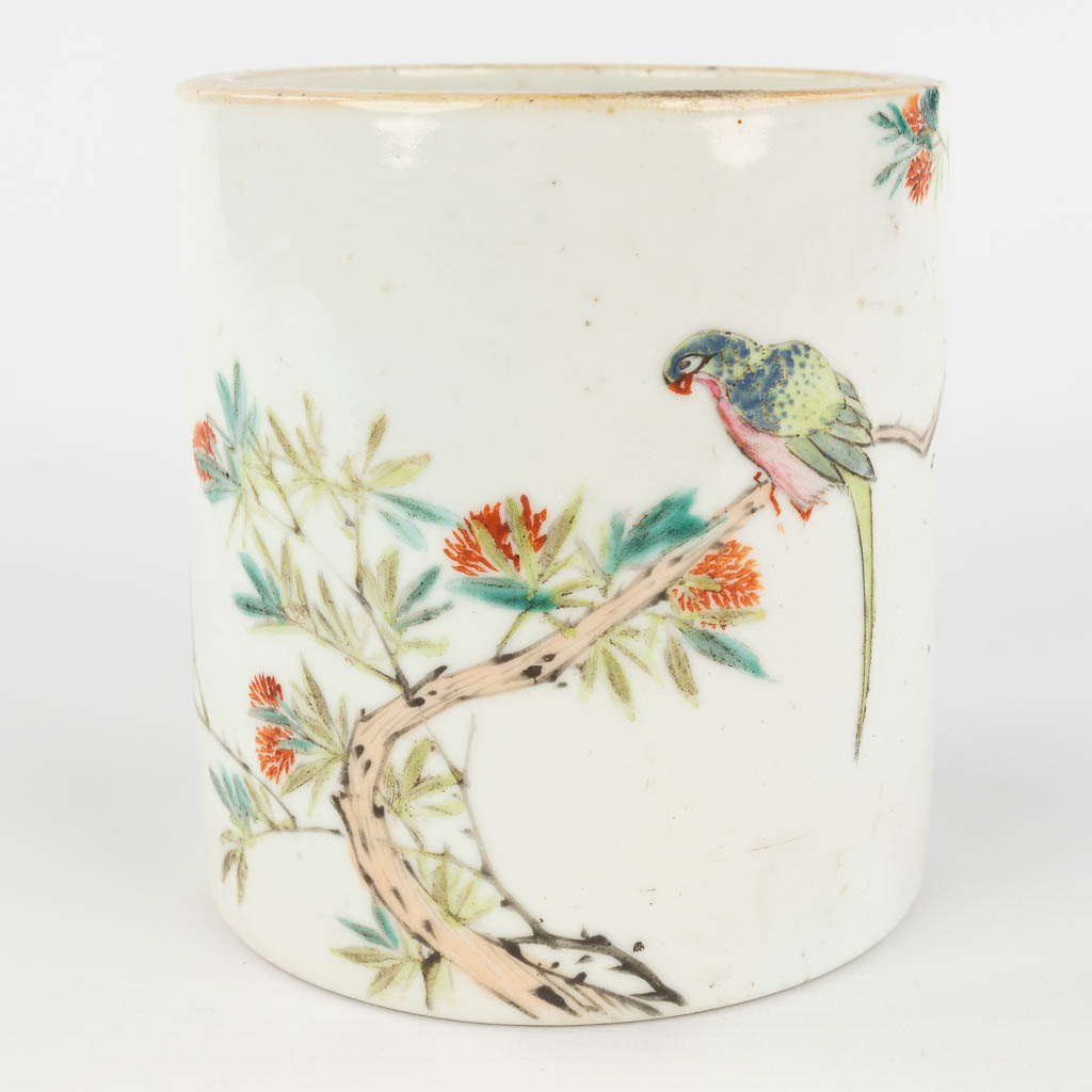 A Chinese brush pot, decorated with branches and a parrot. 19th/20th C. (H: 13,5 x D: 12,5 cm)