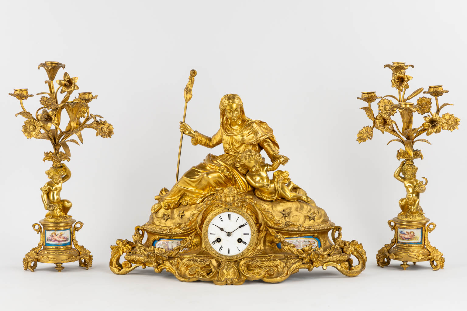 A three-piece mantle garniture clock and candelabra, gilt bronze and Sèvres porcelain, 19th C. (L:20 x W:53 x H:52 cm)