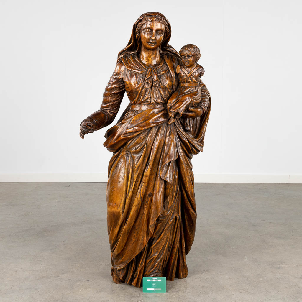 Een antieke houtsculptuur van Madonna met kind. 17de/18de eeuw (L:27 x W:44 x H:99 cm)