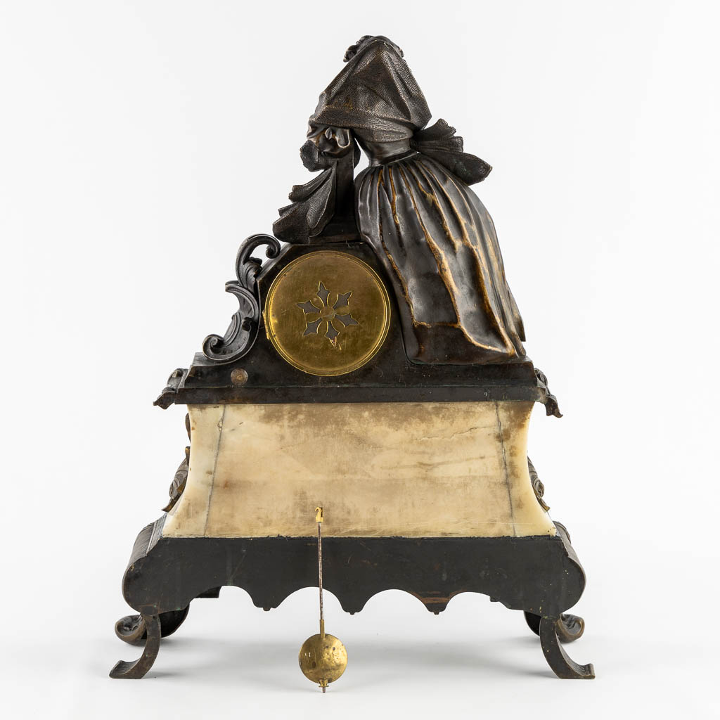 A mantle clock with a lady, patinated bronze on marble. (c.1900).