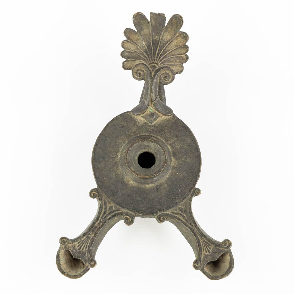 Een antieke bronzen, tweelobbige olielamp. (L:15 x W:24 x H:9 cm)