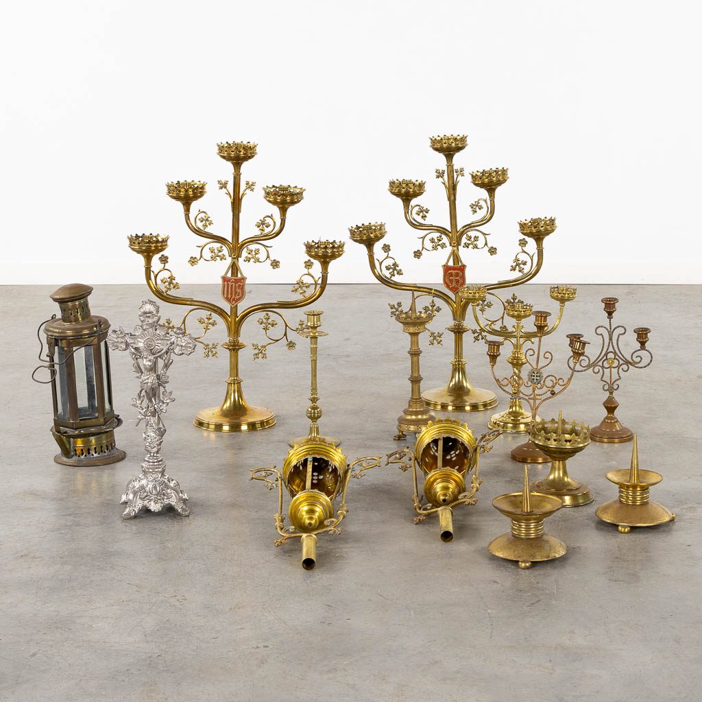 A large collection of church candelabra, lights and a crucifix, brass. (W:46 x H:61 cm)