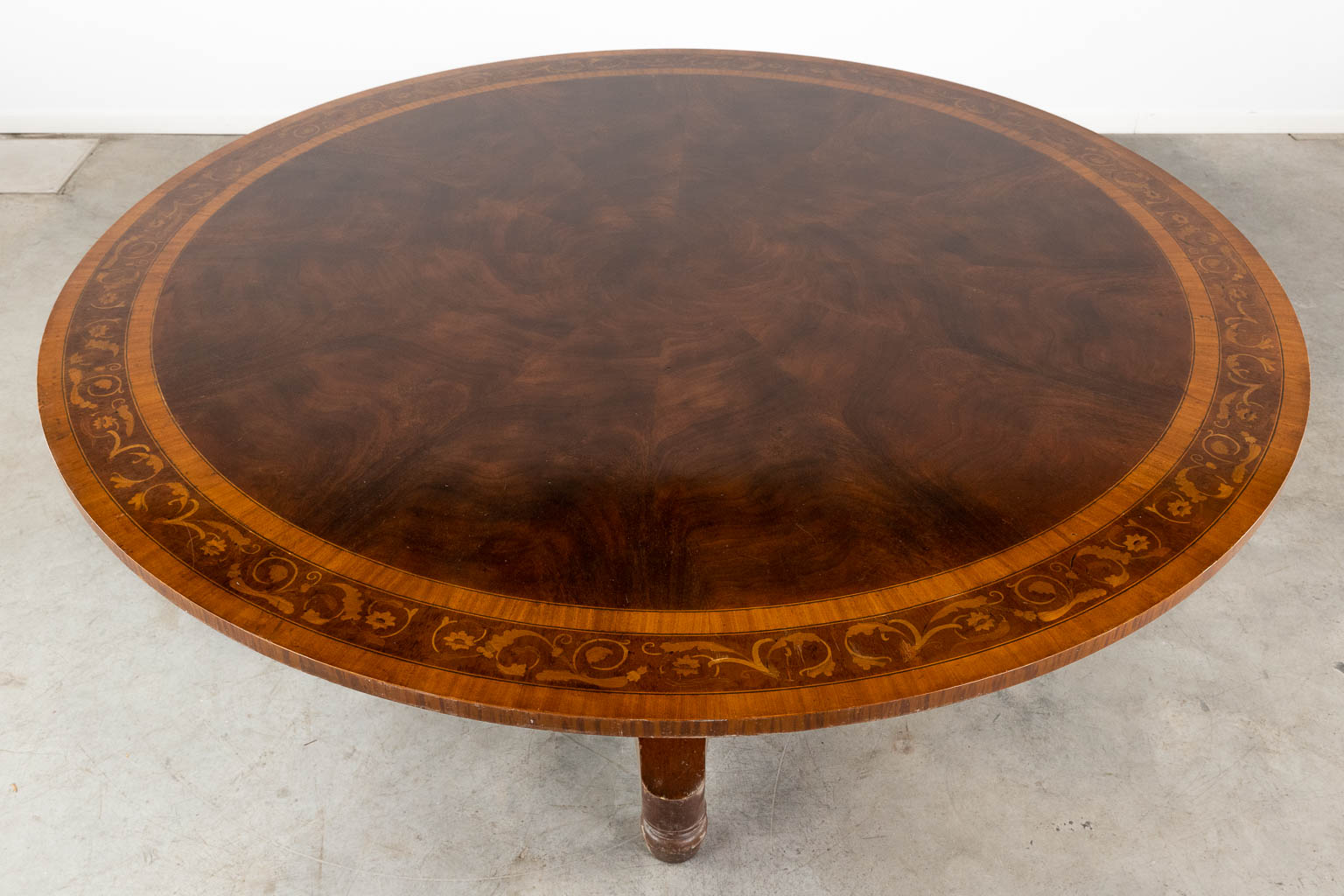 An exceptionally large round table with a marquetry veneer top. (H:77 x D:183 cm)