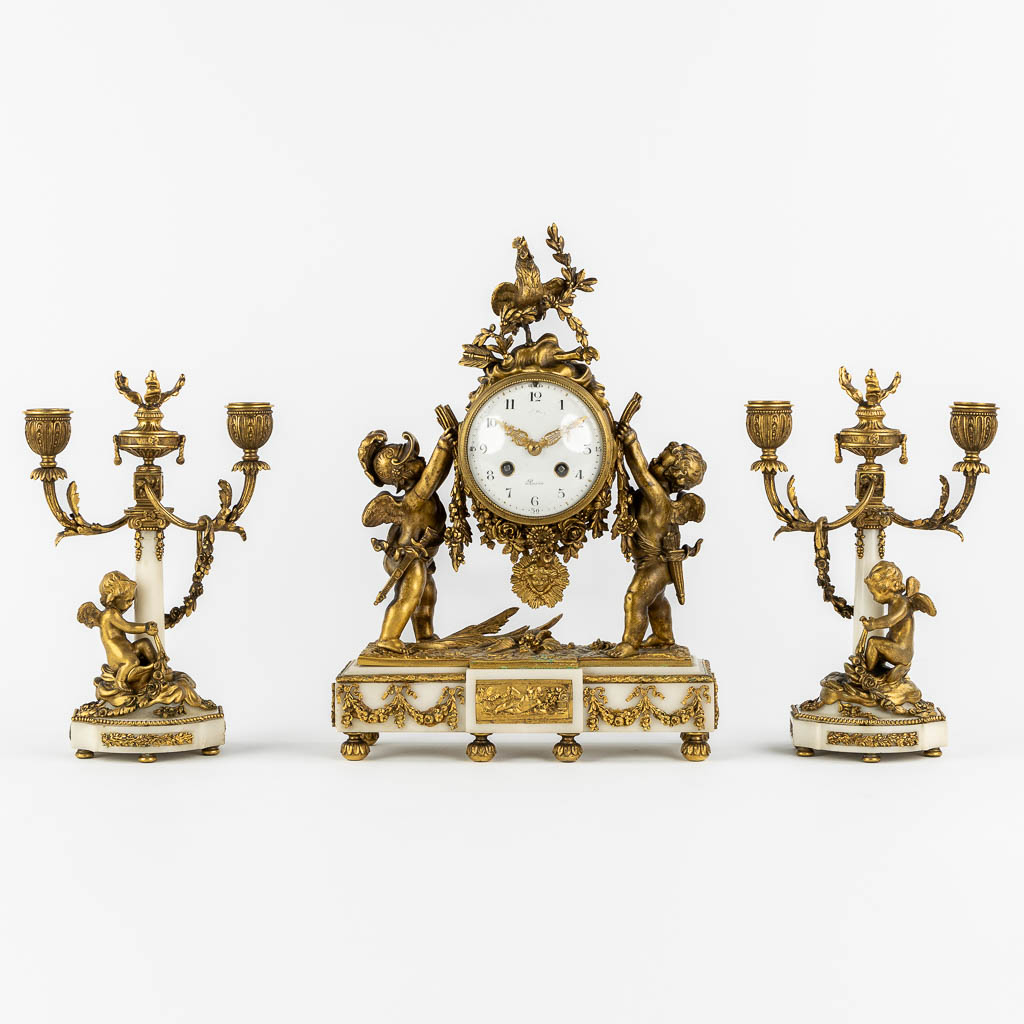 A three-piece mantle garniture clock and candelabra, bronze and marble, 19th C. (L:11 x W:27 x H:36 cm)