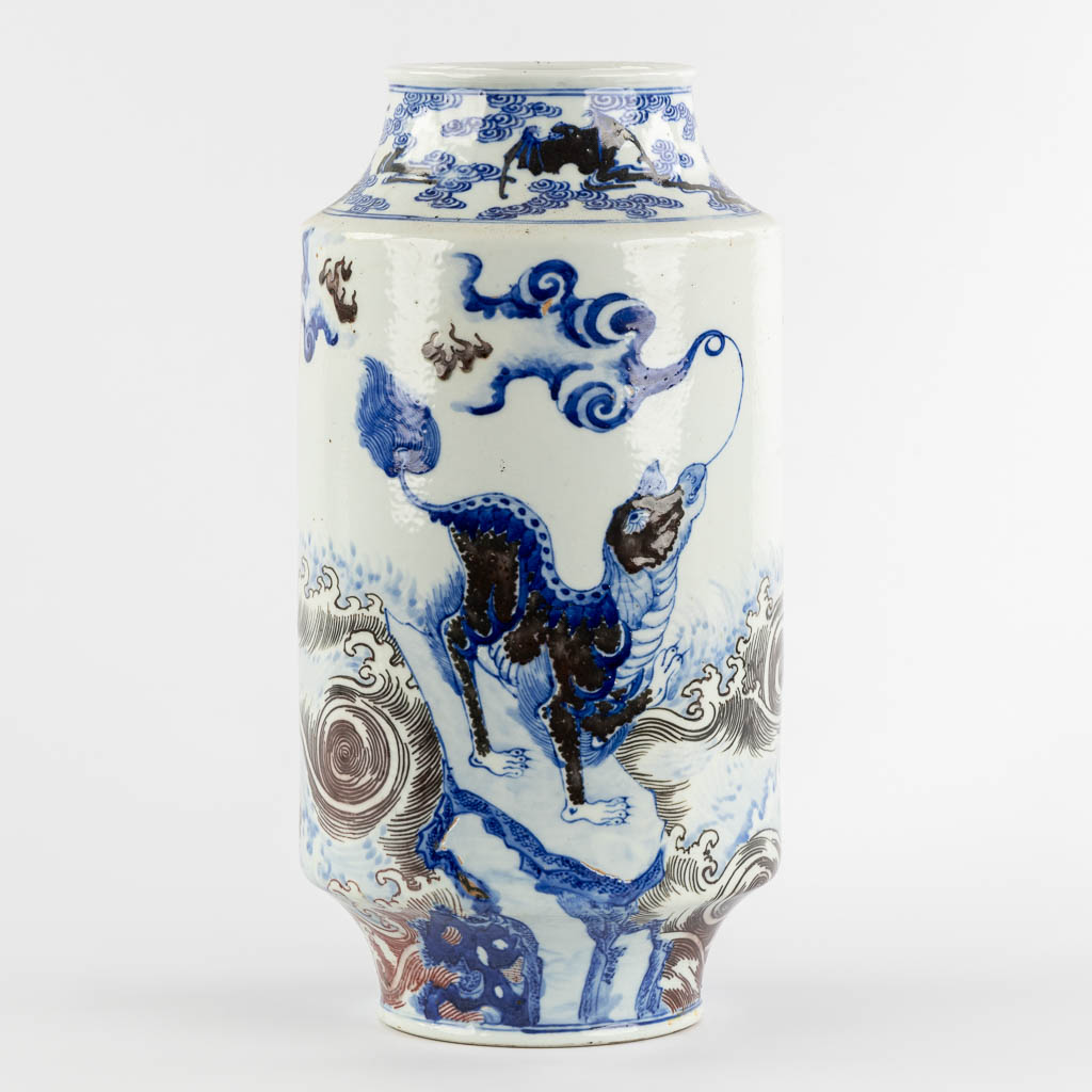 A Chinese Rouleau vase with a blue, black and white Foo Dog. Kangxi mark, 19th C. (H:39 x D:29 cm)