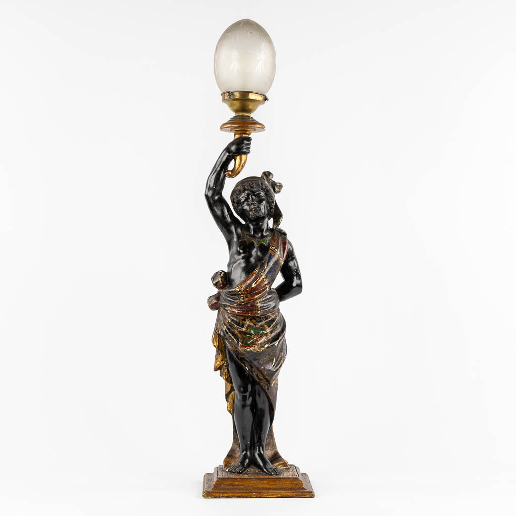 A sculptured wood 'Blackamoor' table lamp, patinated and gilt. Circa 1920.