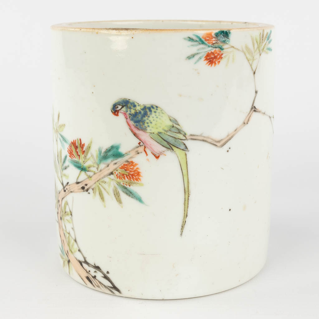 A Chinese brush pot, decorated with branches and a parrot. 19th/20th C. (H: 13,5 x D: 12,5 cm)