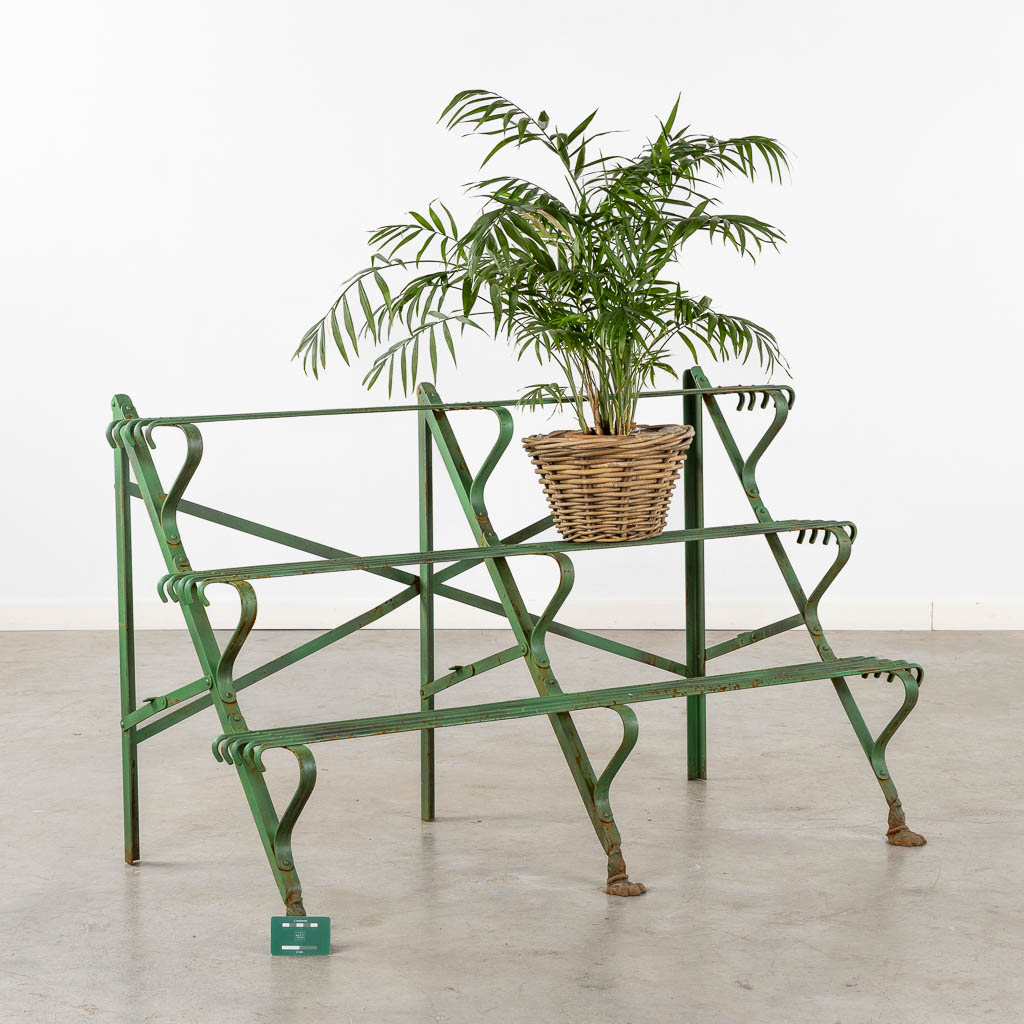 A green-patinated metal garden rack standing on claw feet. (L:60 x W:124 x H:75 cm)