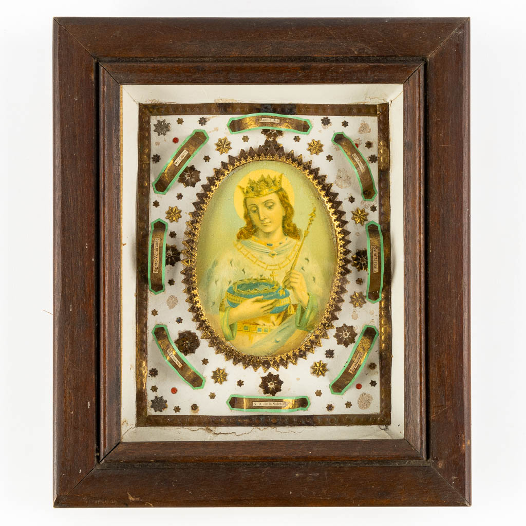 A vintage reliquary frame with 8 relics, in the middle an image of 