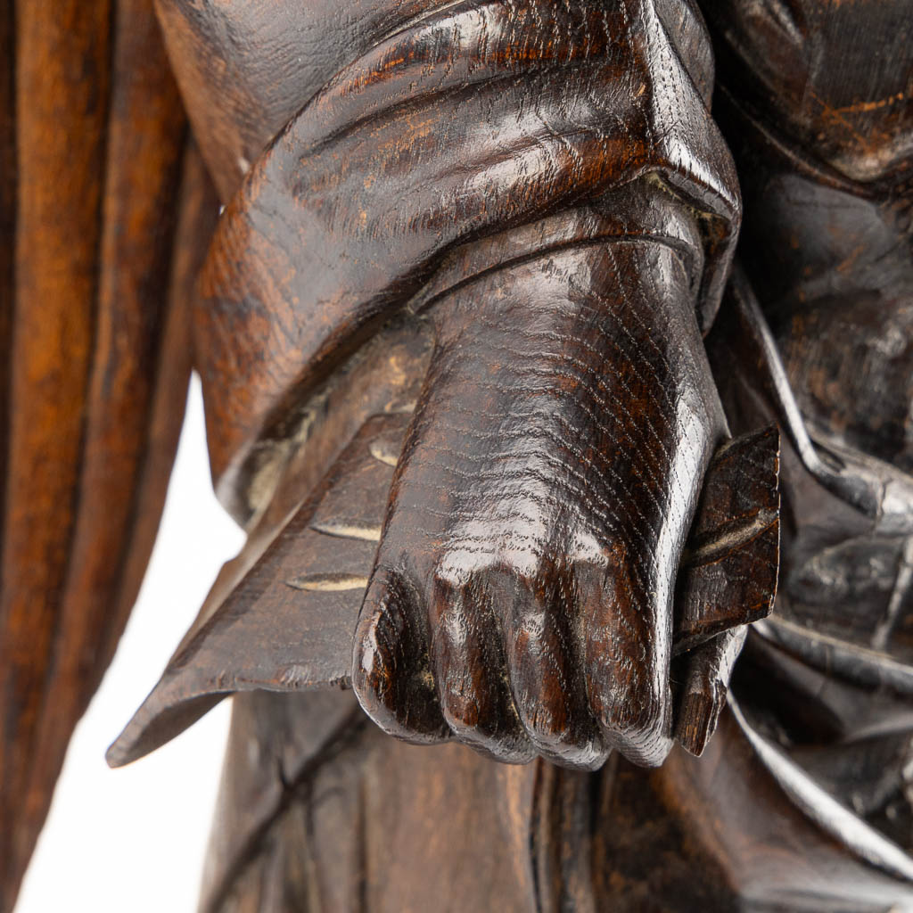 A large wood sculptured figurine of an angel, oak, 19th C. (L:20 x W:40 x H:95 cm)