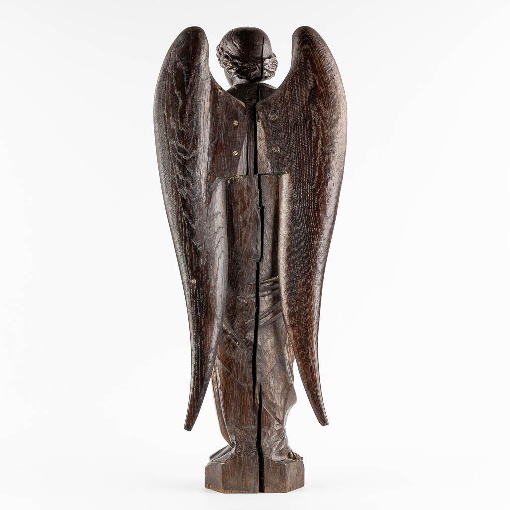 A large wood sculptured figurine of an angel, oak, 19th C. (L:20 x W:40 x H:95 cm)