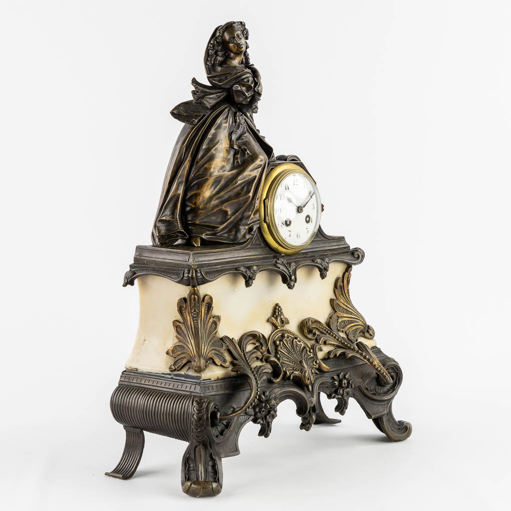 A mantle clock with a lady, patinated bronze on marble. (c.1900).