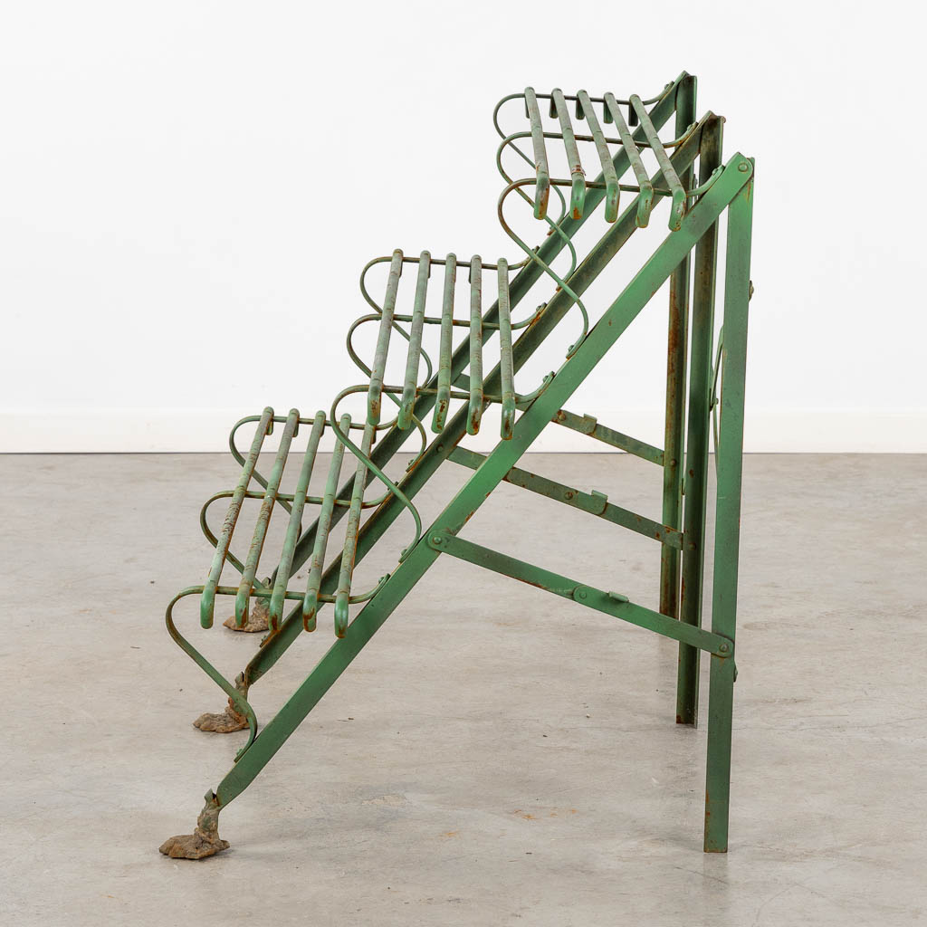 A green-patinated metal garden rack standing on claw feet. (L:60 x W:124 x H:75 cm)