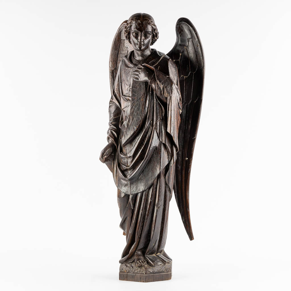 A large wood sculptured figurine of an angel, oak, 19th C. (L:20 x W:40 x H:95 cm)