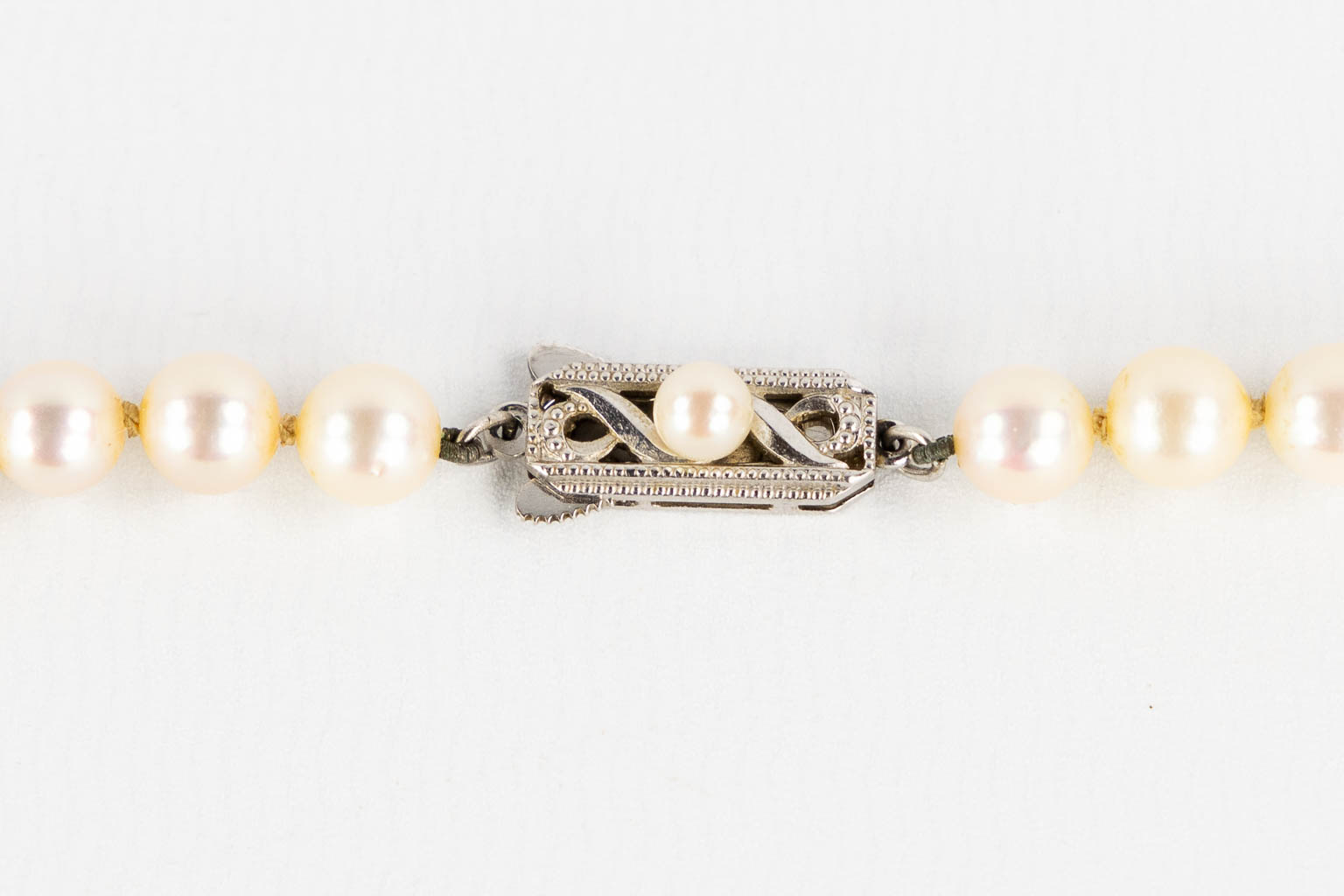 Mikimoto, a pearl necklace and tie clasp, 14kt white and yellow gold, 1965. 