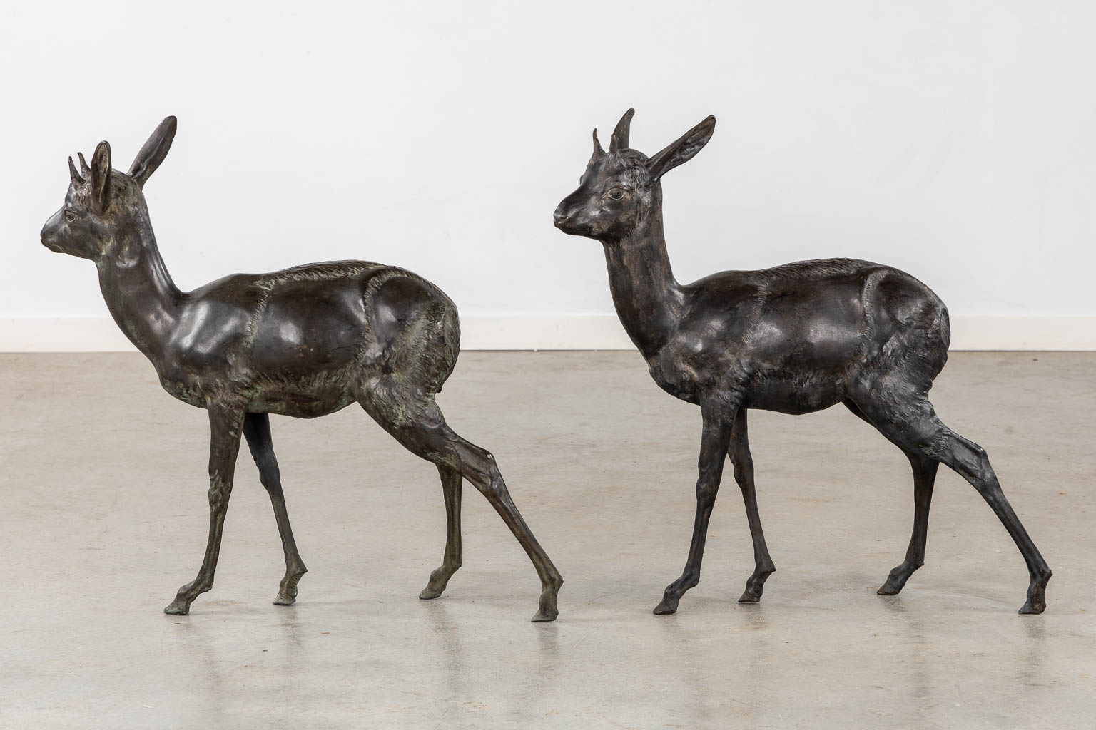 A very decorative pair of deer, patinated bronze. Circa 1970. (L:16 x W:70 x H:66 cm)