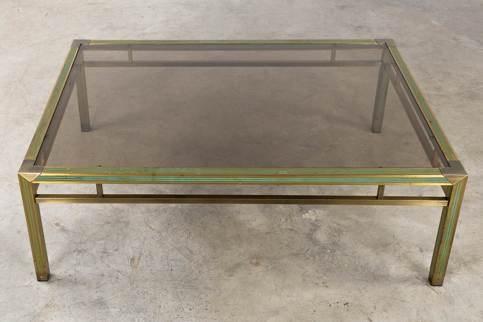 Een mid-century salontafel, messing en glas in de stijl van Belgo Chrome. (L:88 x W:128 x H:43 cm)