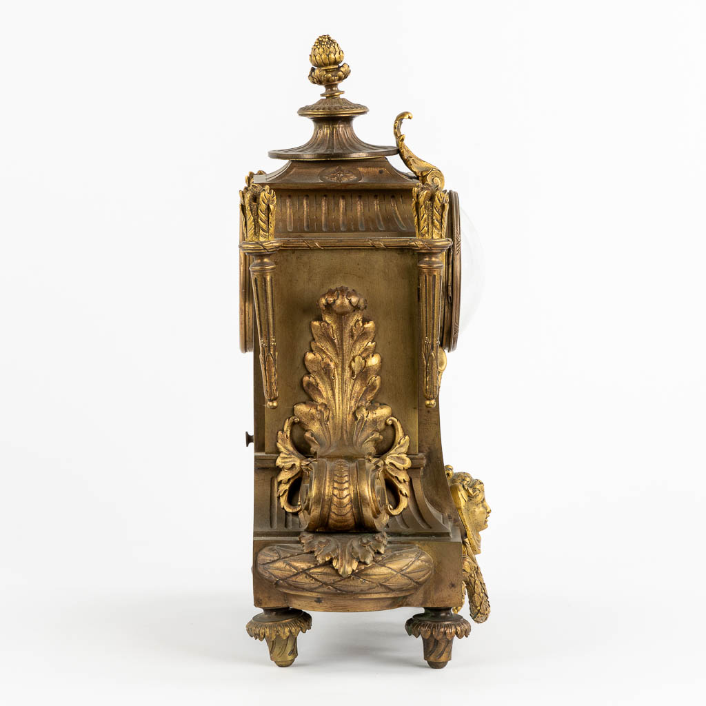 A mantle clock, gilt bronze in a Louis XVI style. Circa 1900. (L:16 x W:32 x H:41 cm)