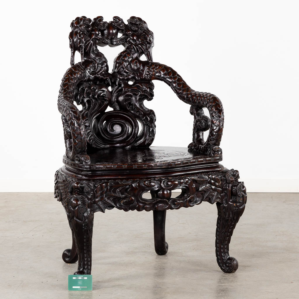 A Chinese sculptured hardwood armchair with a dragon decor. 