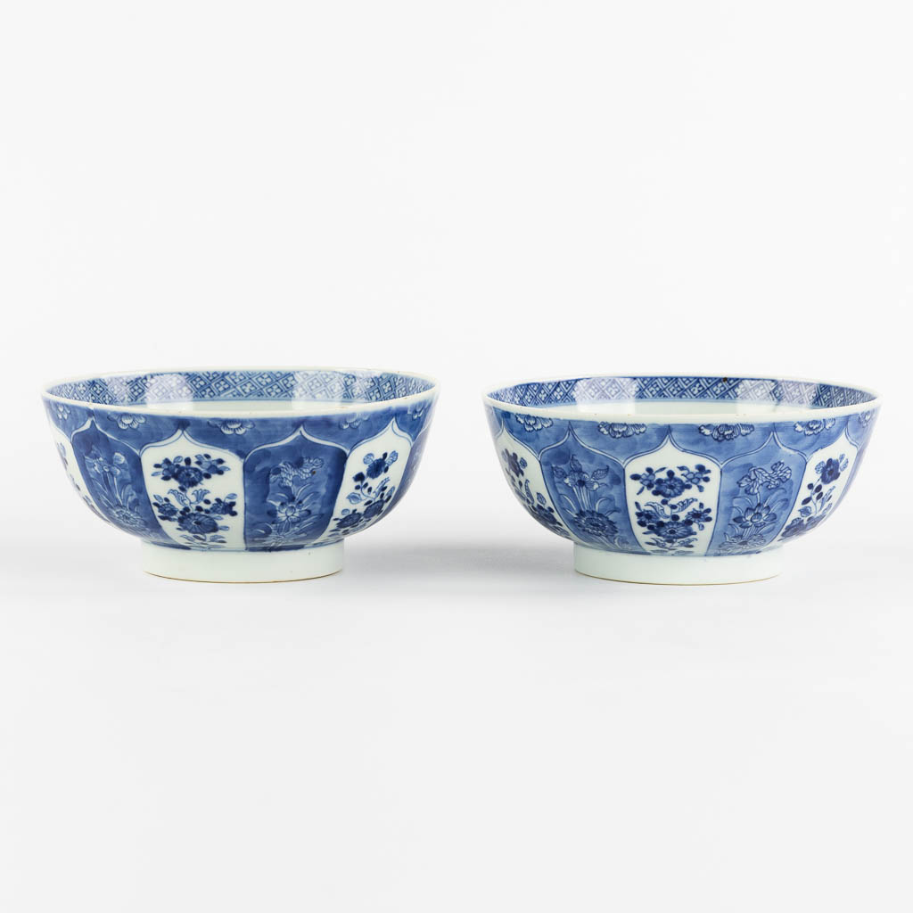 A pair of Chinese bowls, blue-white with a floral and pomegranate decor. 19th C. (H:8,5 x D:18 cm)