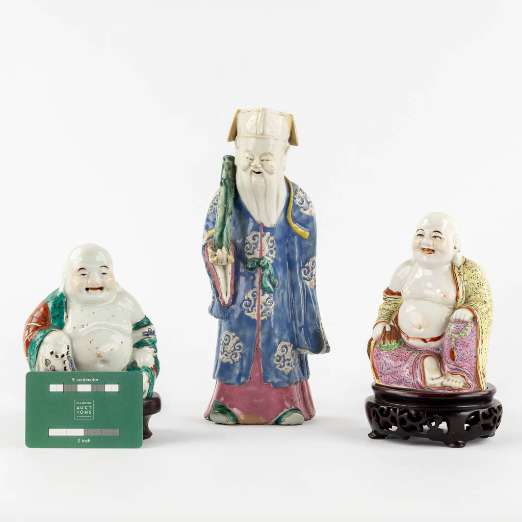 Drie polychroom porseleinen figuren van Boeddha en Lao Tse. (L:7 x W:10 x H:24 cm)