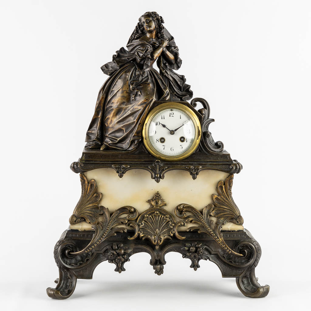 A mantle clock with a lady, patinated bronze on marble. (c.1900).