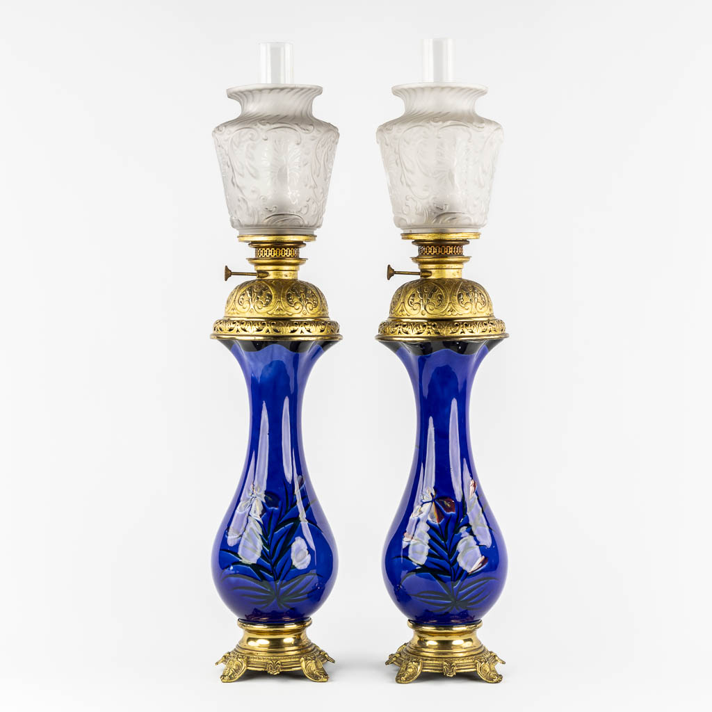 A pair of large oil lamps, porcelain and brass. Circa 1900. 