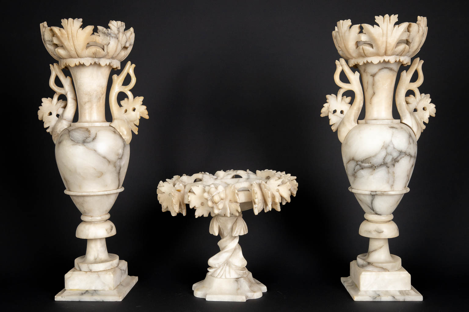 A three piece mantle garniture set, sculptured alabaster. (H:45 x D:15 cm)