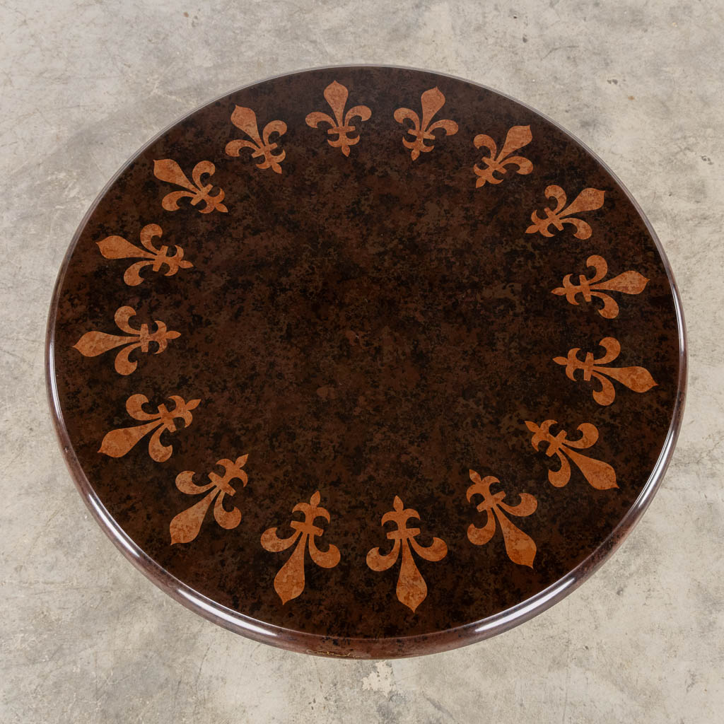 A decorative side table with a Fleur De Lys decor.