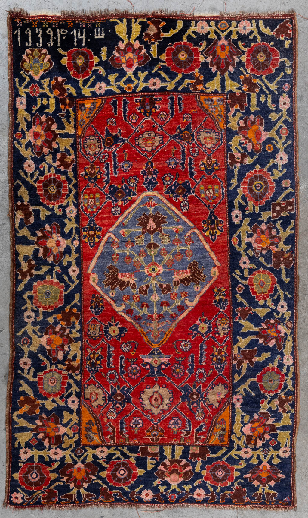 An Oriental hand-made carpet, dated 1939.. (W:124 x H:196 cm)