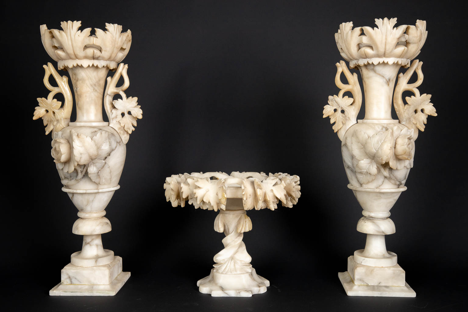 A three piece mantle garniture set, sculptured alabaster. (H:45 x D:15 cm)