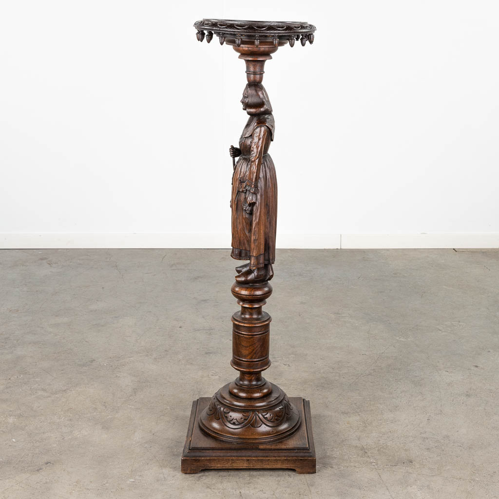 A pedestal with a wood sculptured figurine in Breton style. Circa 1900. (L: 31,5 x W: 31,5 x H: 107 cm)