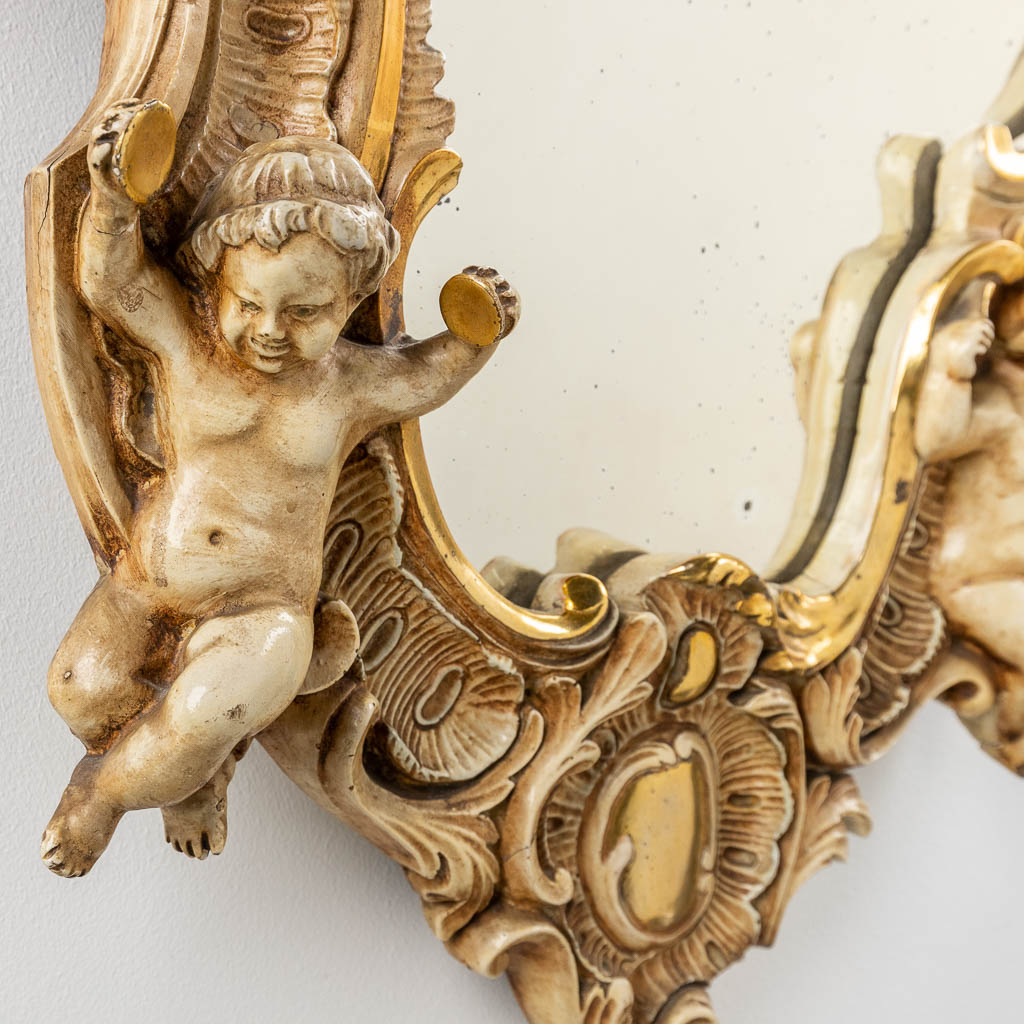 An antique mirror with musical putti. 1886. (W: 60 x H: 97 cm)