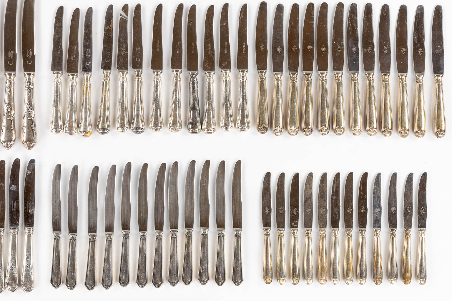 Twelve sets of twelve silver-plated knives. 