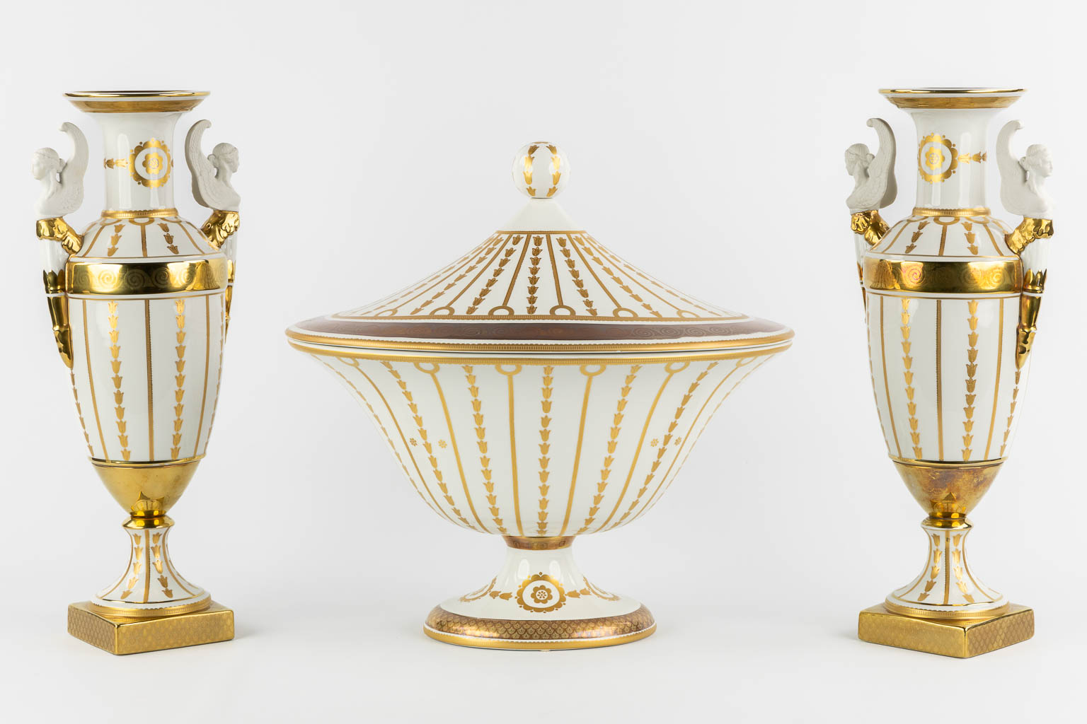 Mangani, Italy, a three-piece garniture, gilt porcelain in Empire style. (L:32 x W:43 x H:40 cm)