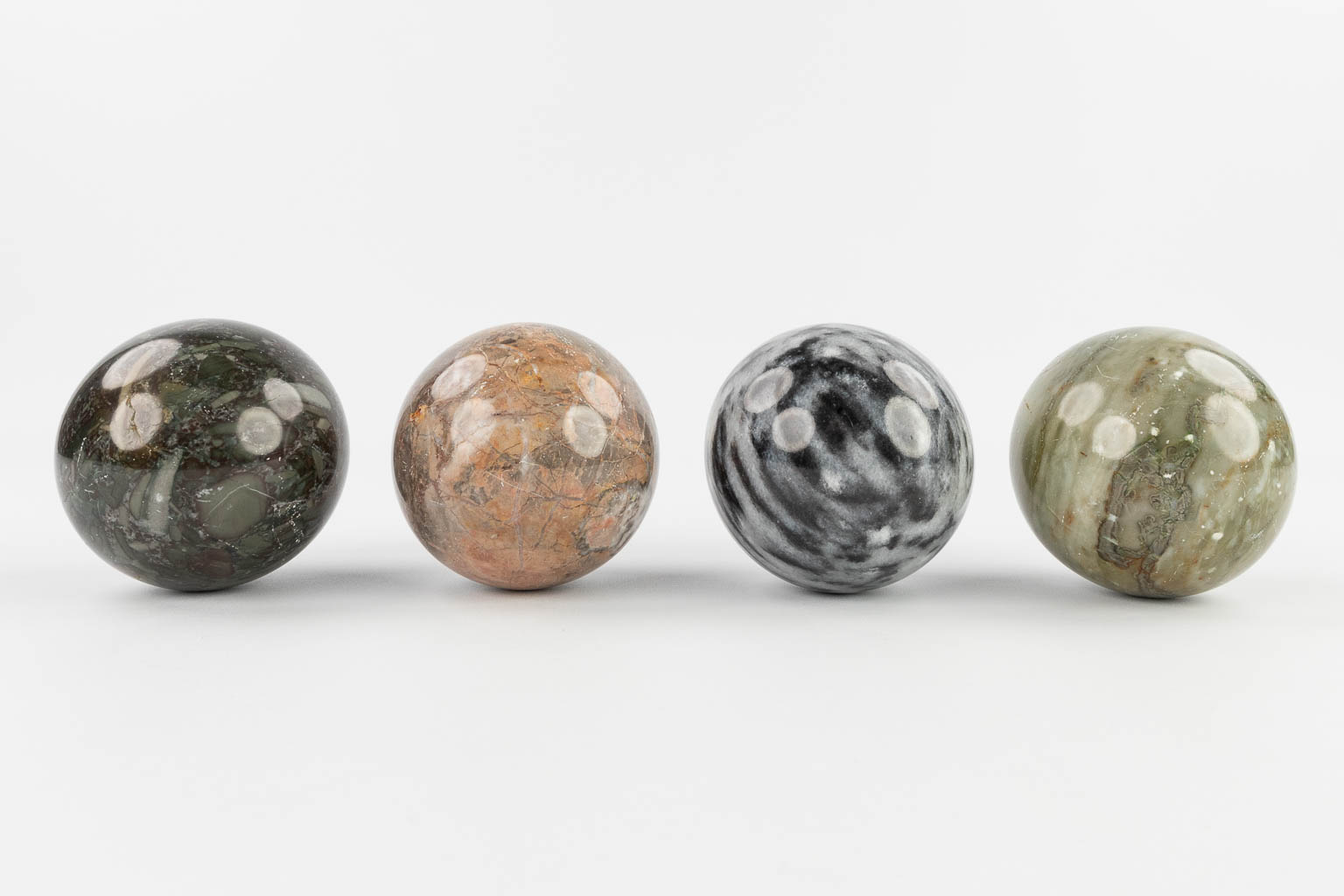 A set of 4 balls made of natural stone and marble. 20th C.  (D:9 cm)