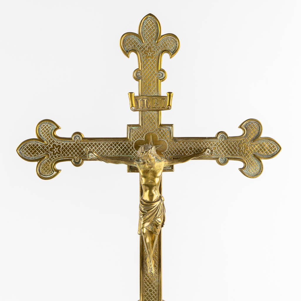 An altar crucifix with two matching candelabra, brass in a Gothic Revival style. (W:23 x H:58 cm)