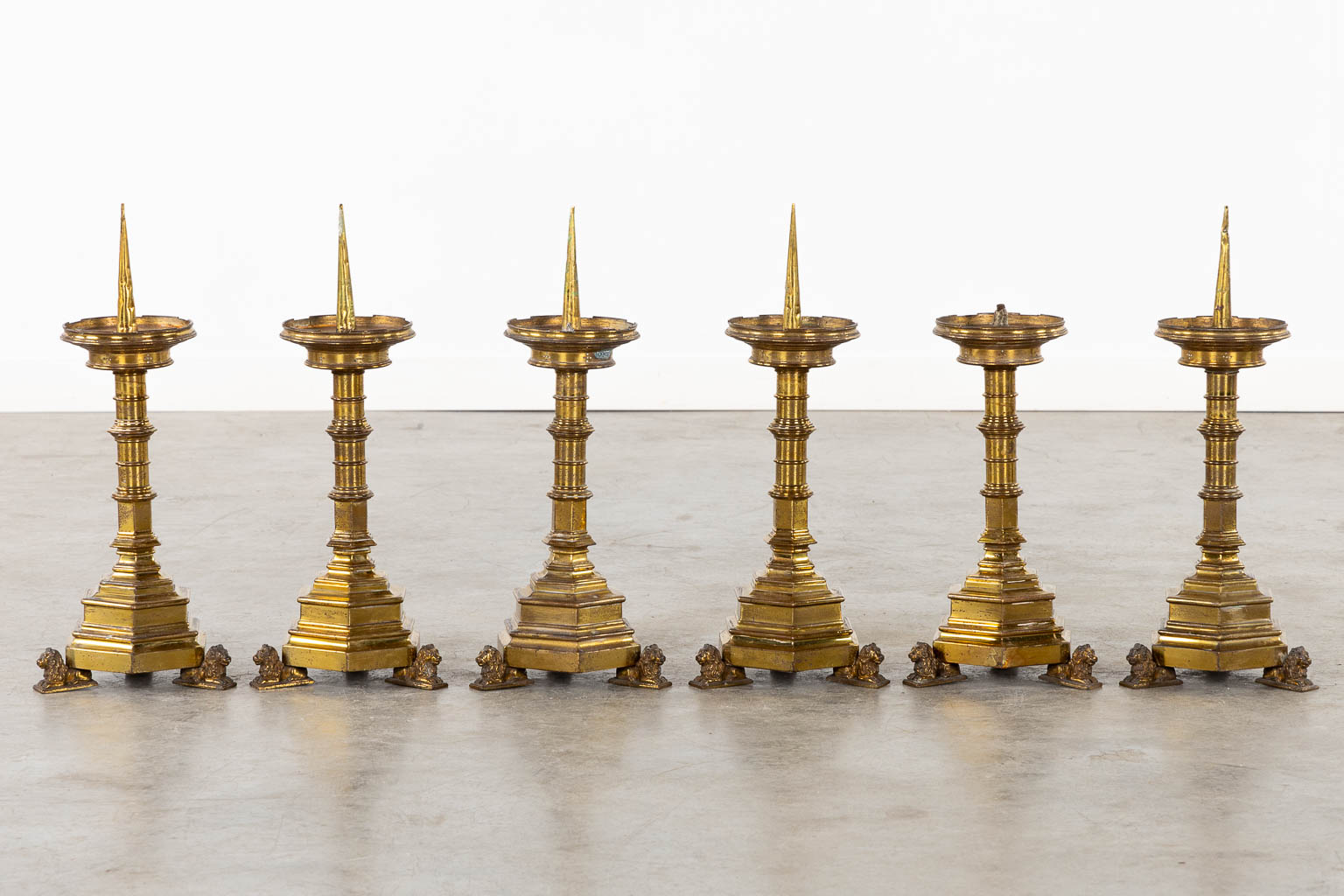 A set of six candlesticks, bronze standing on lions, Gothic Revival style. (L:17 x W:17 x H:45 cm)