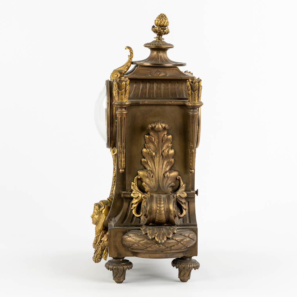 A mantle clock, gilt bronze in a Louis XVI style. Circa 1900. (L:16 x W:32 x H:41 cm)