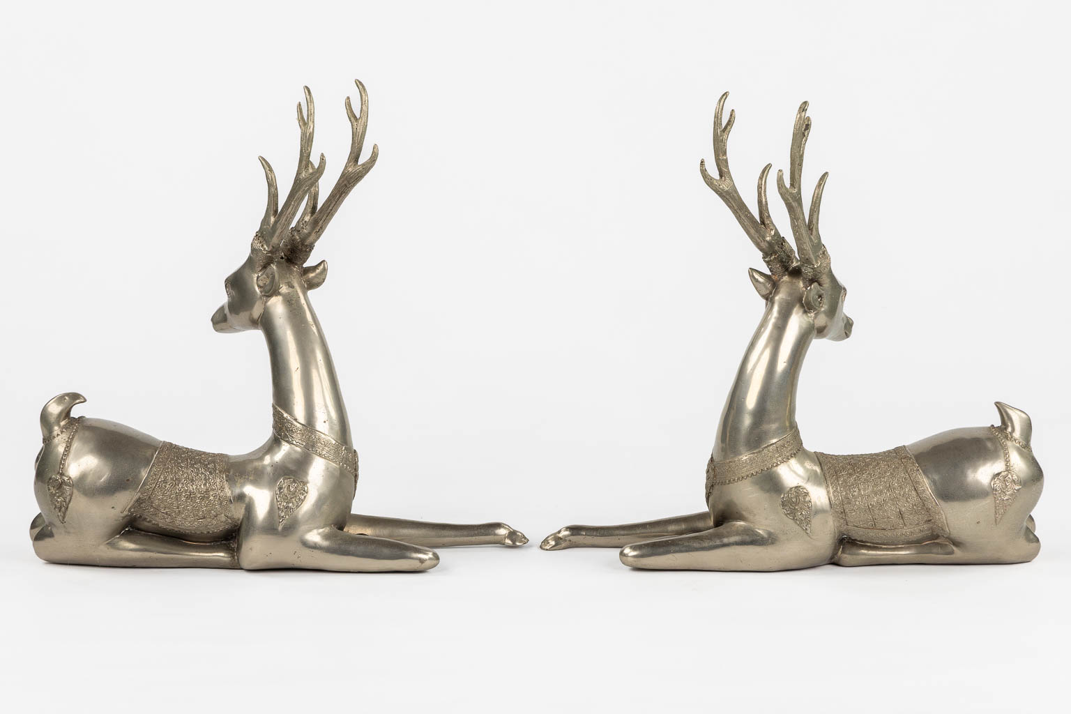 A pair of resting Temple Deer, silver-plated bronze. Circa 1970. (L:22 x W:51 x H:51 cm)