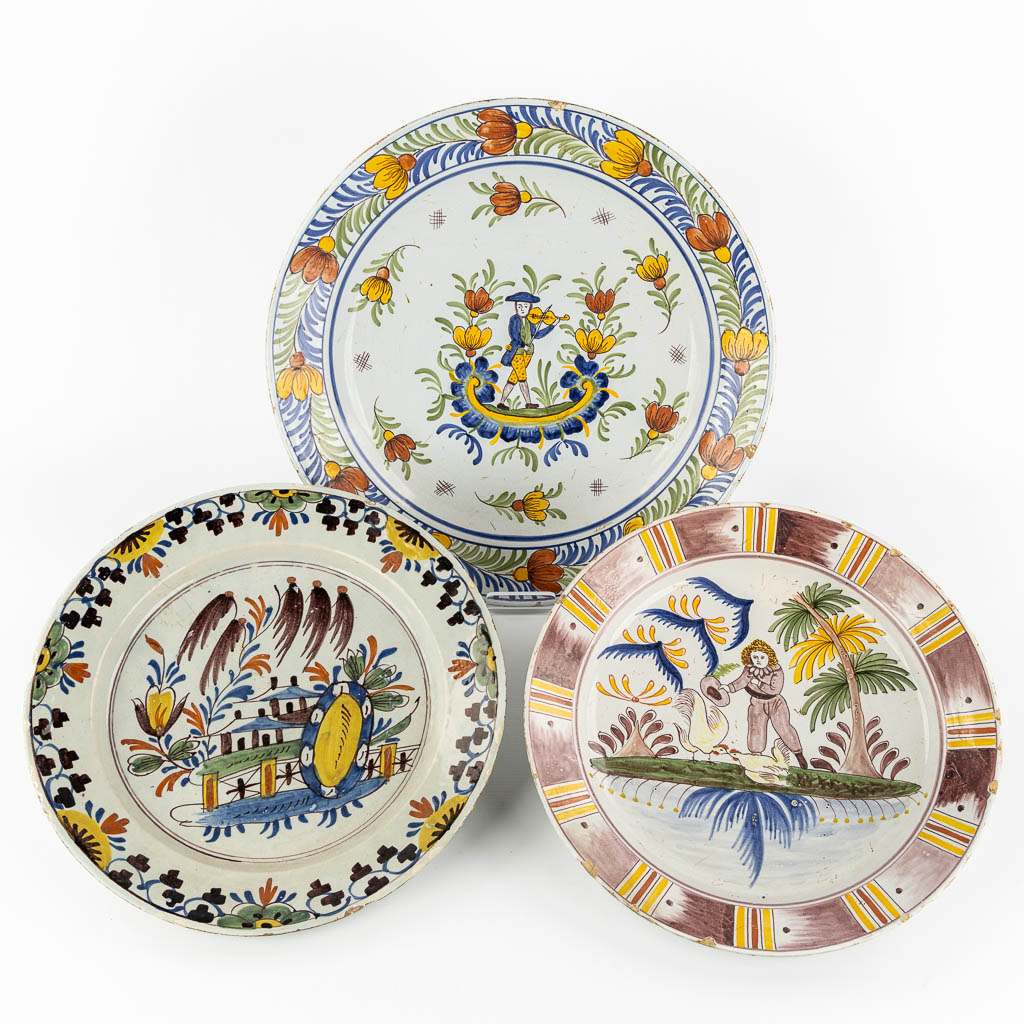 Three antique plates with a polychrome decor, Delft and Faience De L'est. 