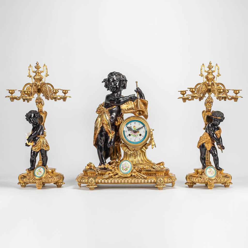 Ijver Onnauwkeurig Voorbereiding Een driedelige schouwgarnituur met bronzen klok en kandelaars, versierd met  putti en handgeschilderde porseleinen plaquettes. | Flanders Auctions