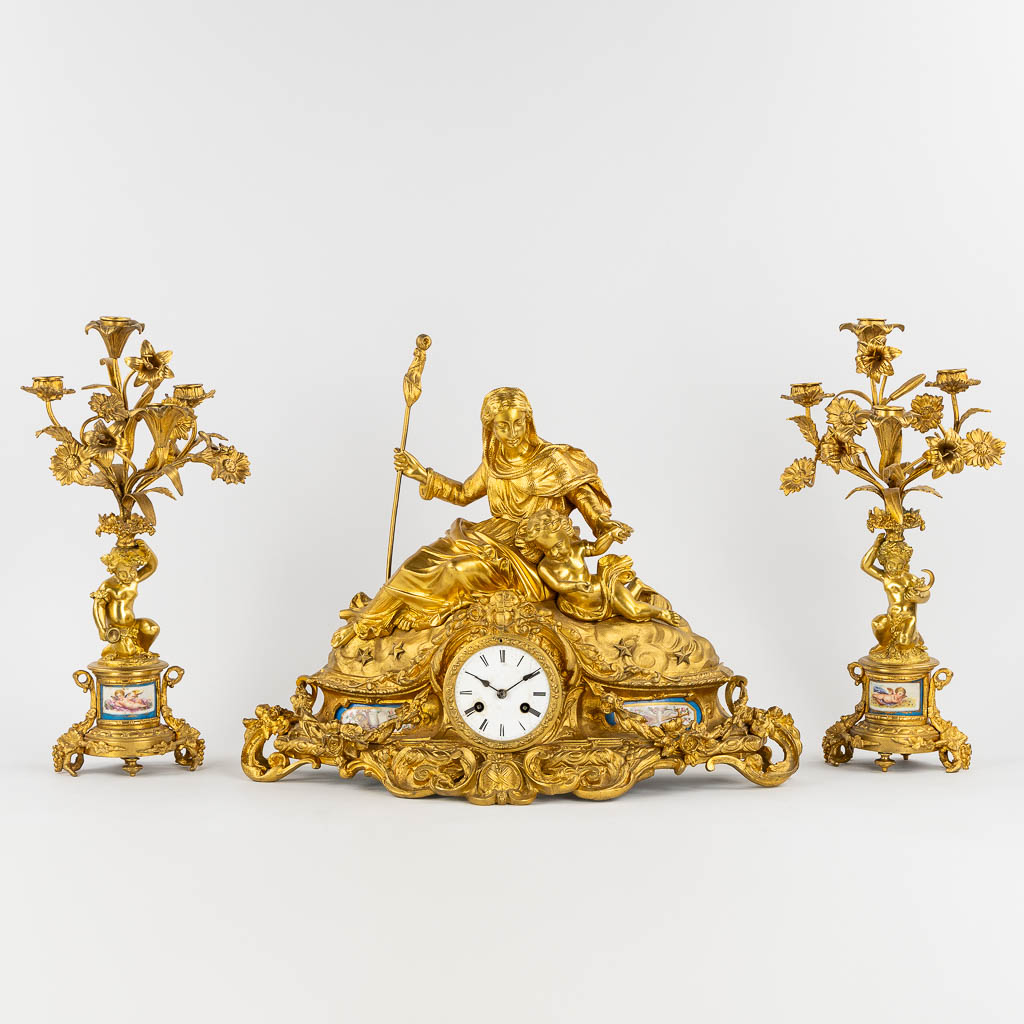 A three-piece mantle garniture clock and candelabra, gilt bronze and Sèvres porcelain, 19th C. (L:20 x W:53 x H:52 cm)