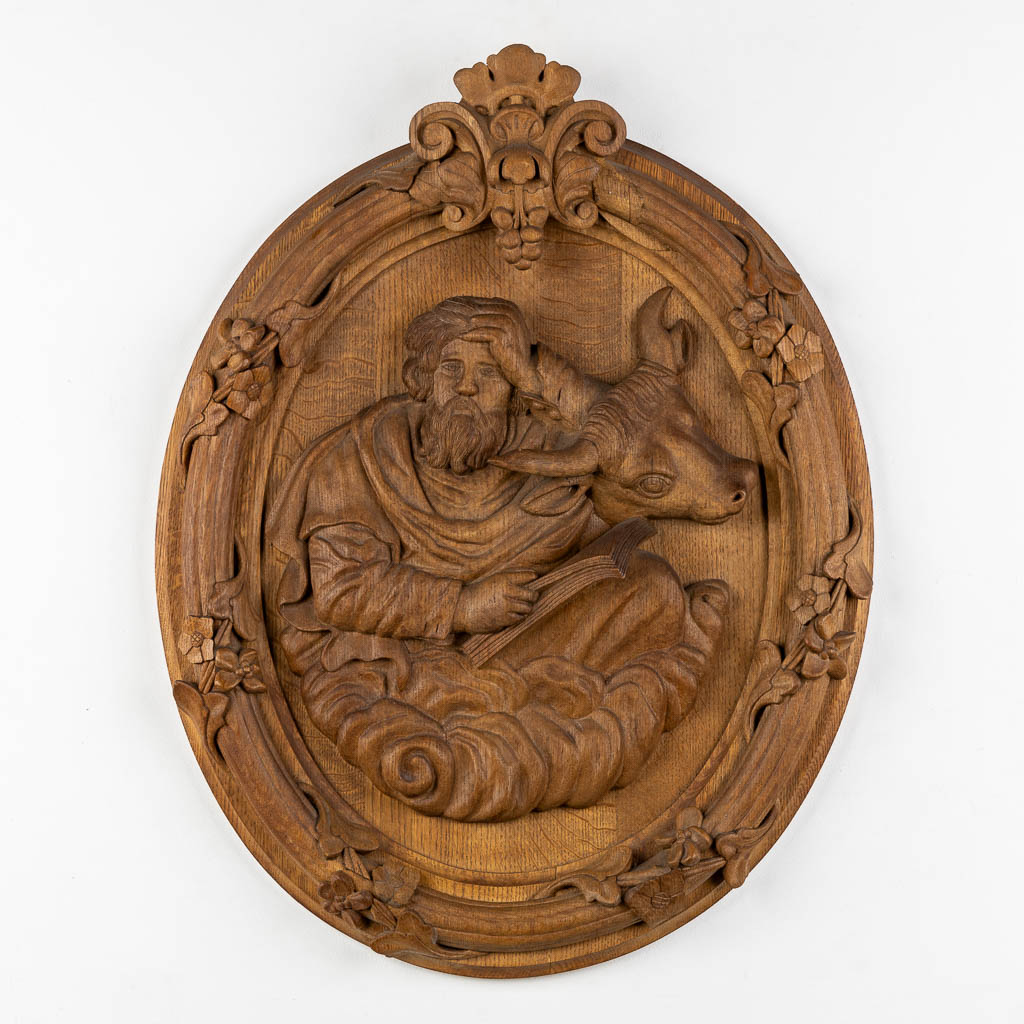 A set of four big oval wood sculptures depicitng 