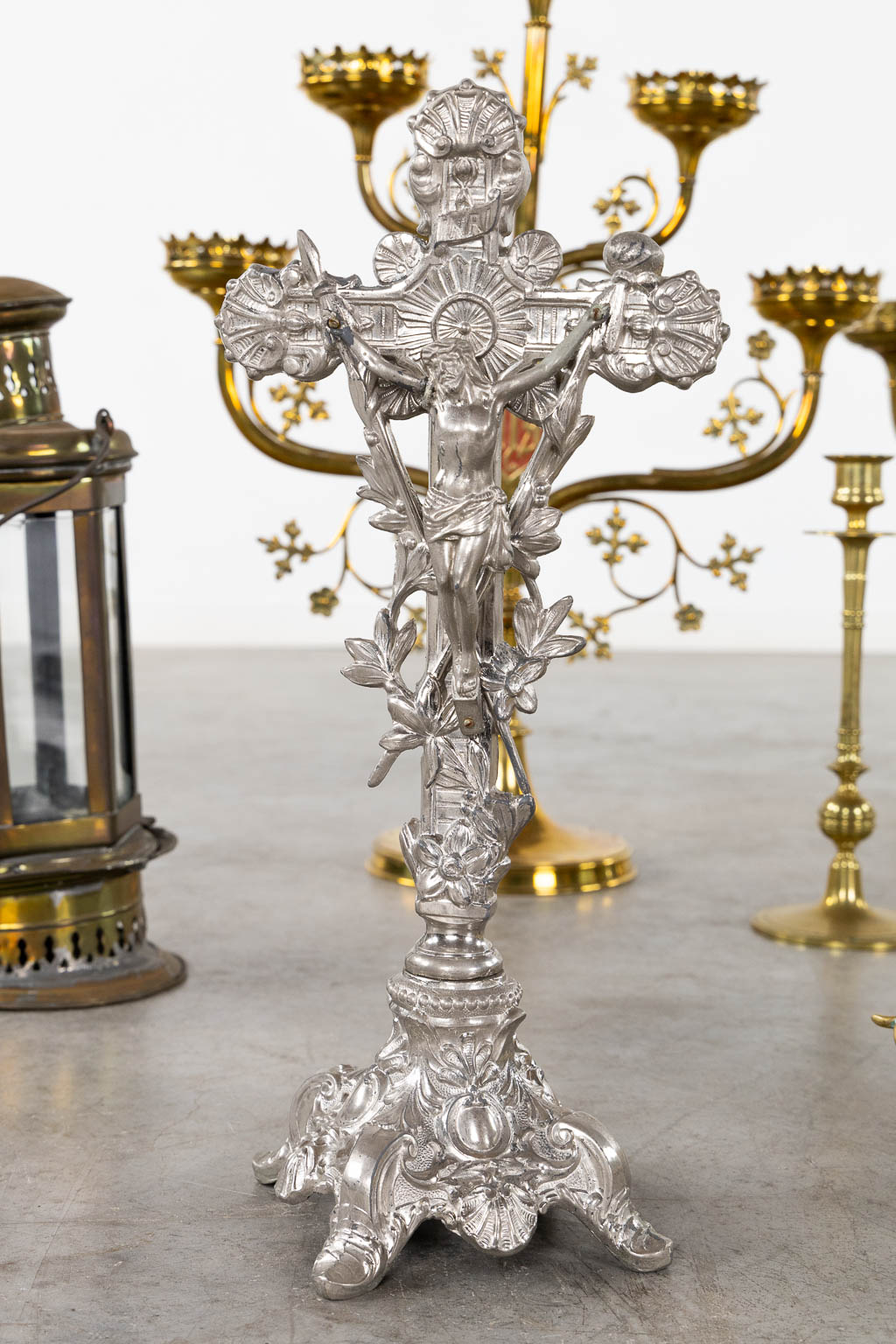 A large collection of church candelabra, lights and a crucifix, brass. (W:46 x H:61 cm)