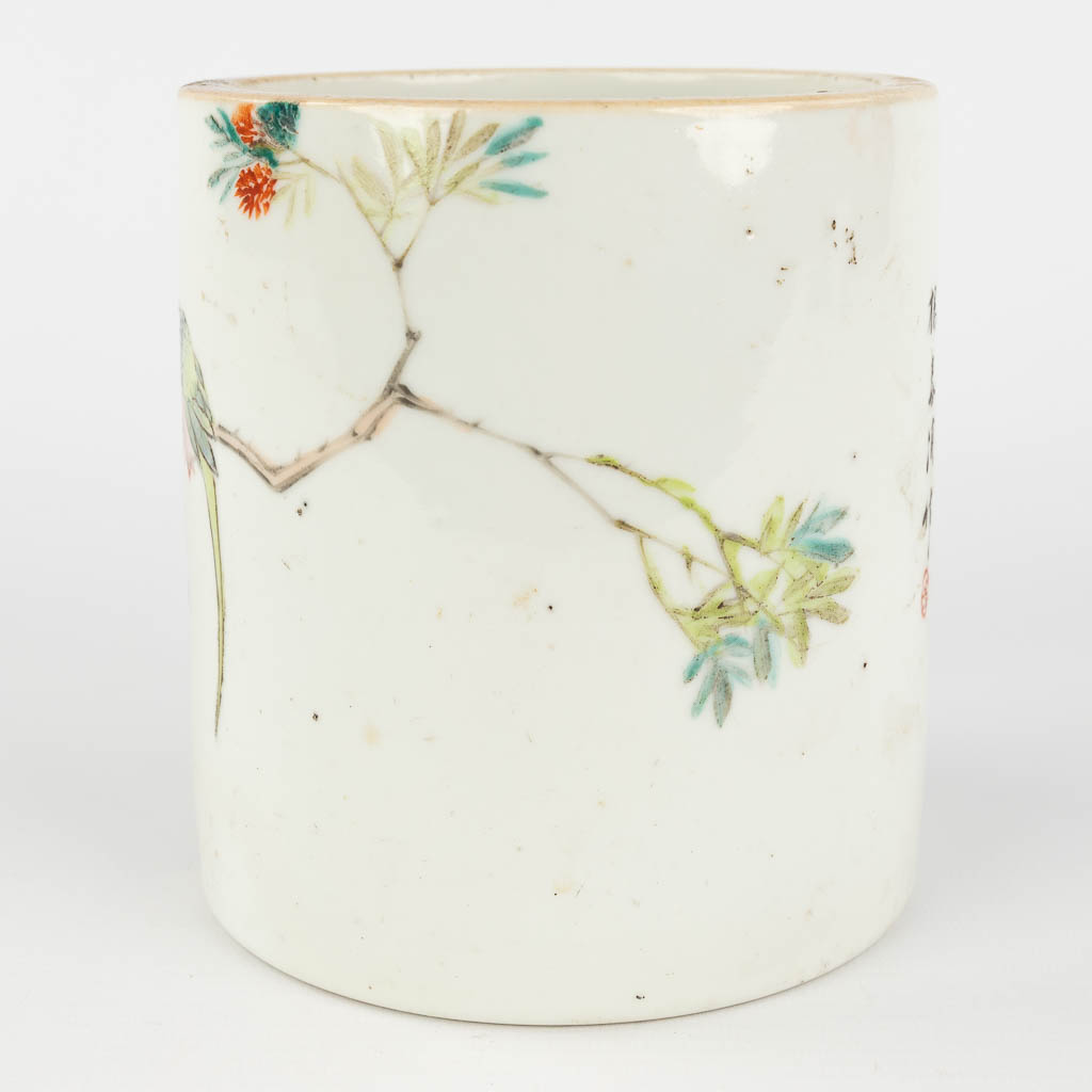 A Chinese brush pot, decorated with branches and a parrot. 19th/20th C. (H: 13,5 x D: 12,5 cm)