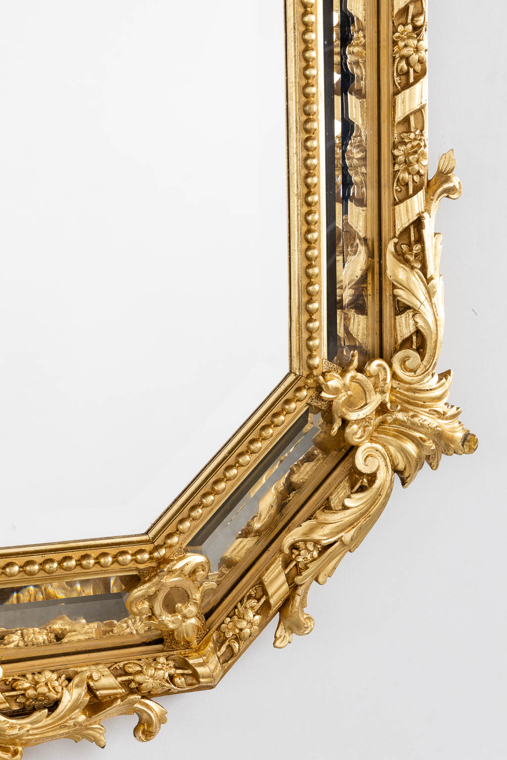 An antique mirror, sculptured gilt stucco and facetted glass, Louis XV style. 19th C. (W:98 x H:140 cm)