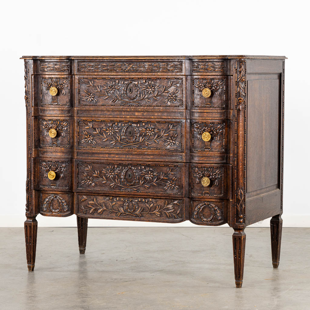 A three-drawer commode, floral wood-sculptures in a Louis XVI style. (L:60 x W:110 x H:99 cm)